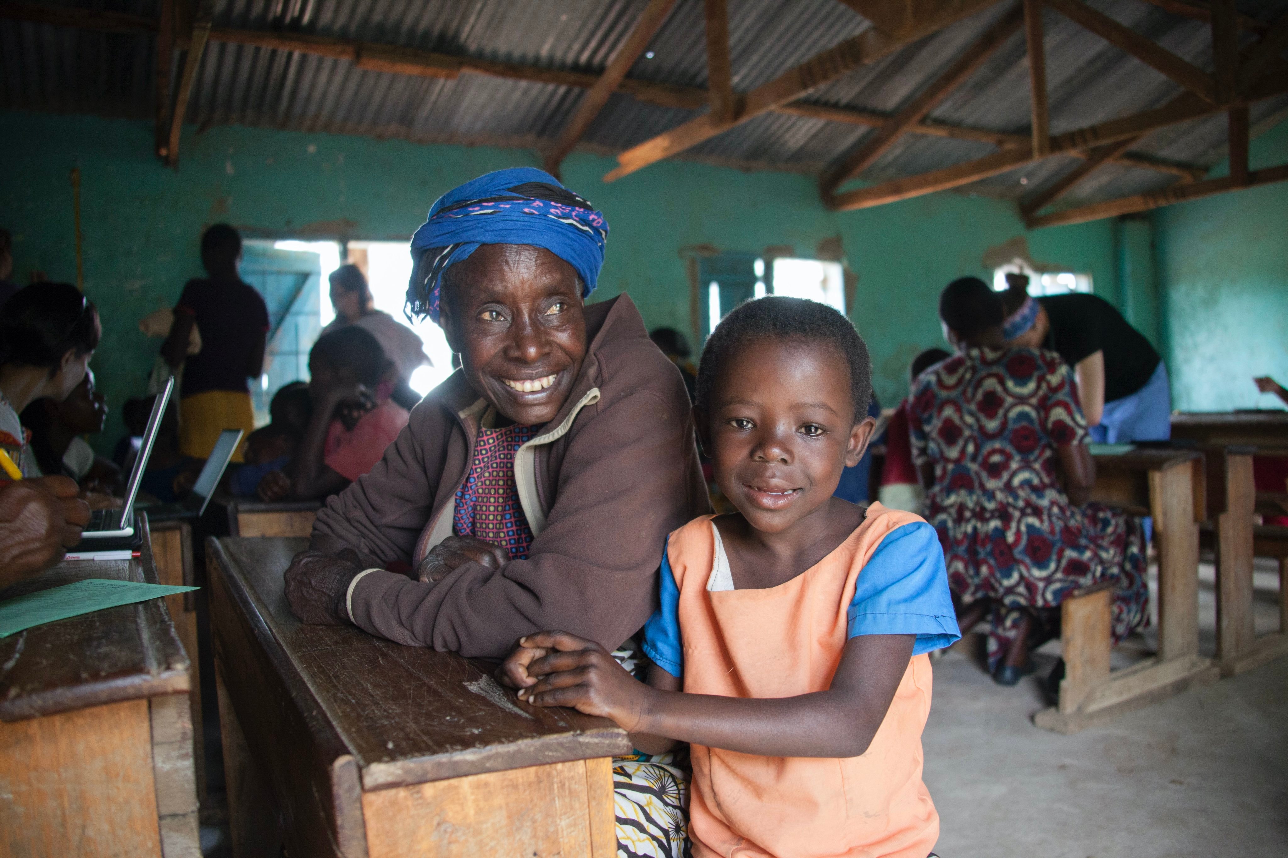 Villager and child smile and pose for picture