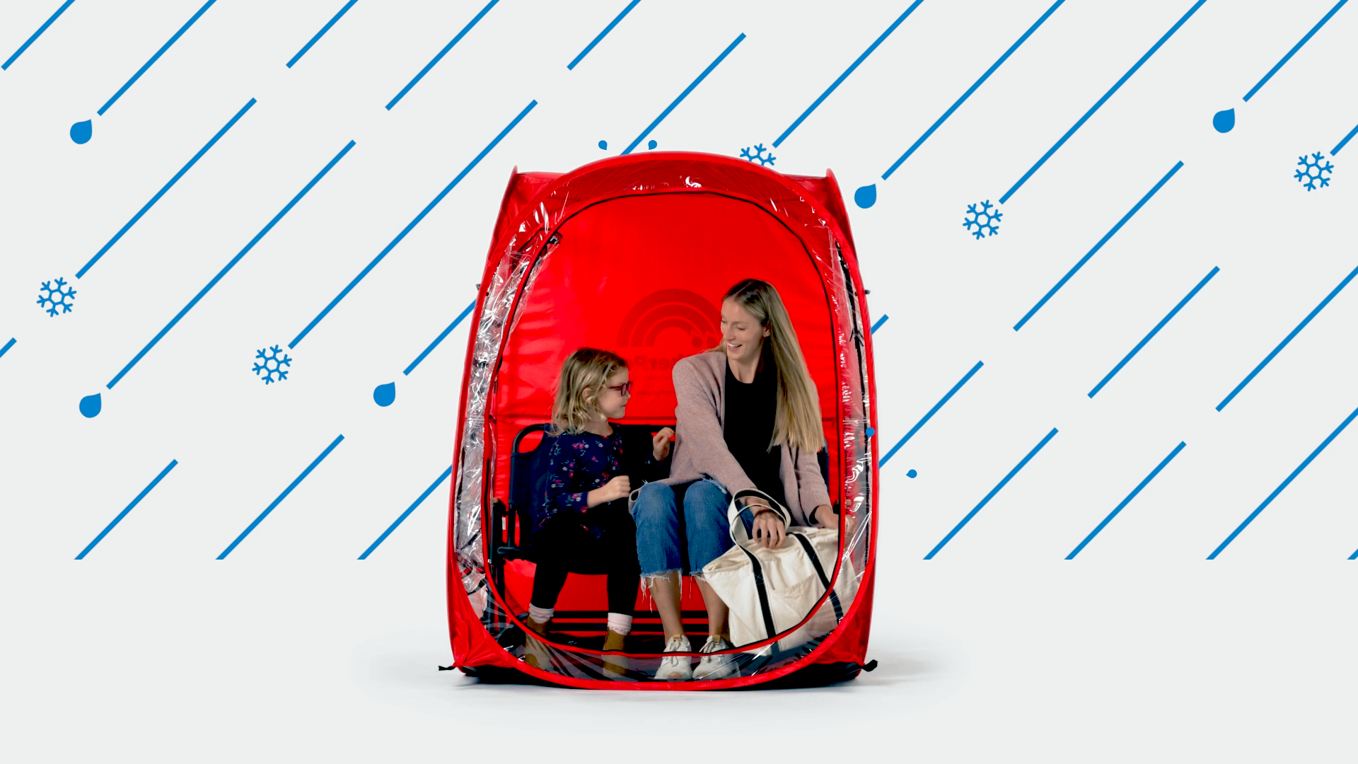 A mother and daughter sit inside a red weatherpod