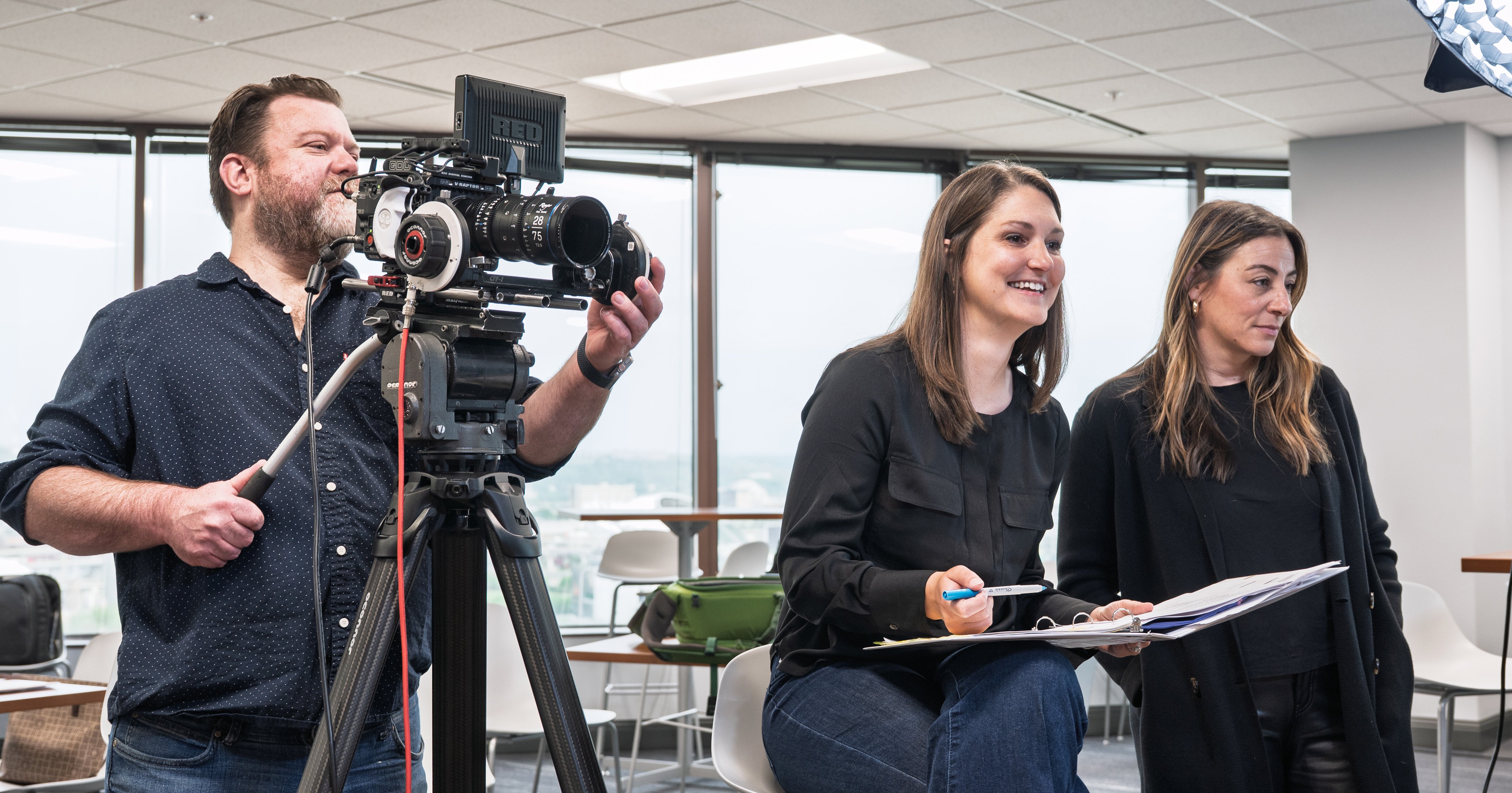 Picture of three video crew members on set with a camera and preproduction documents.