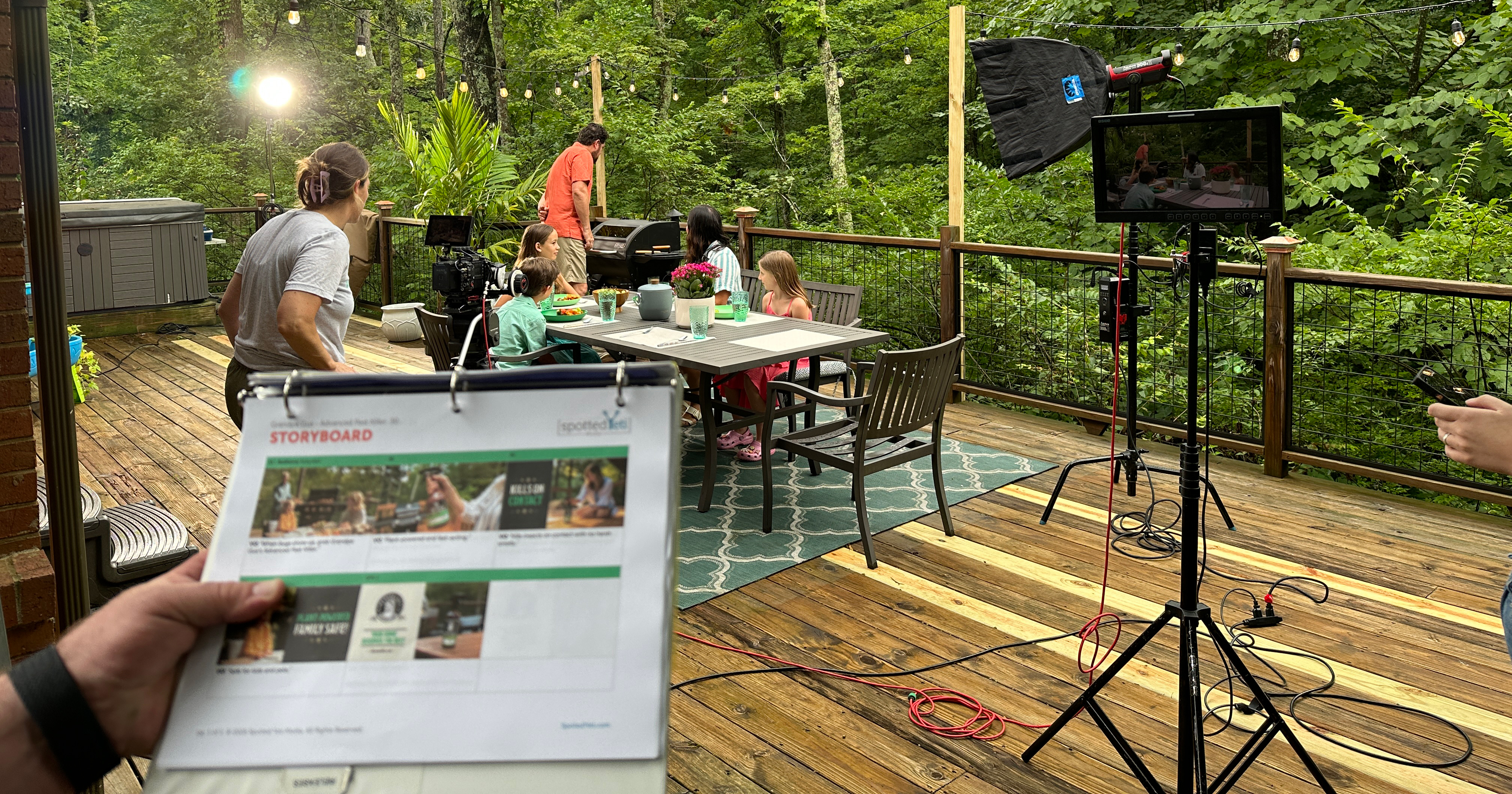 Behind-the-scenes photo of video shoot featuring a family picnic on a deck