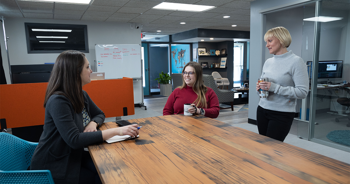 Three female employees of Spotted Yeti media have a meeting. 