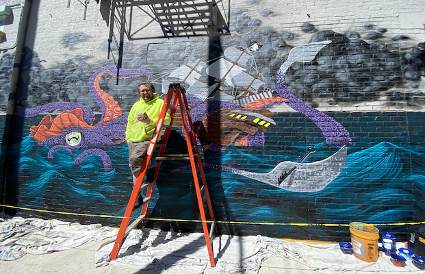 Matthew Grote working on one of his latest mural installations outside Pilar on Court St. in Cincinnati.