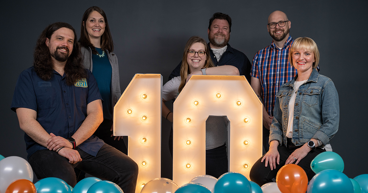 The Spotted Yeti Media employees pose with a number 10