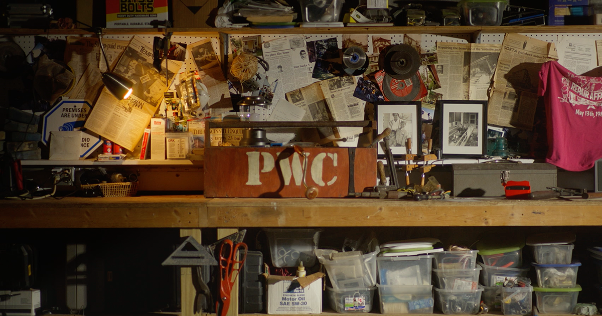 Image of tool bench in a garage. Toolbox has letters "PWC" for People Working Cooperatively.