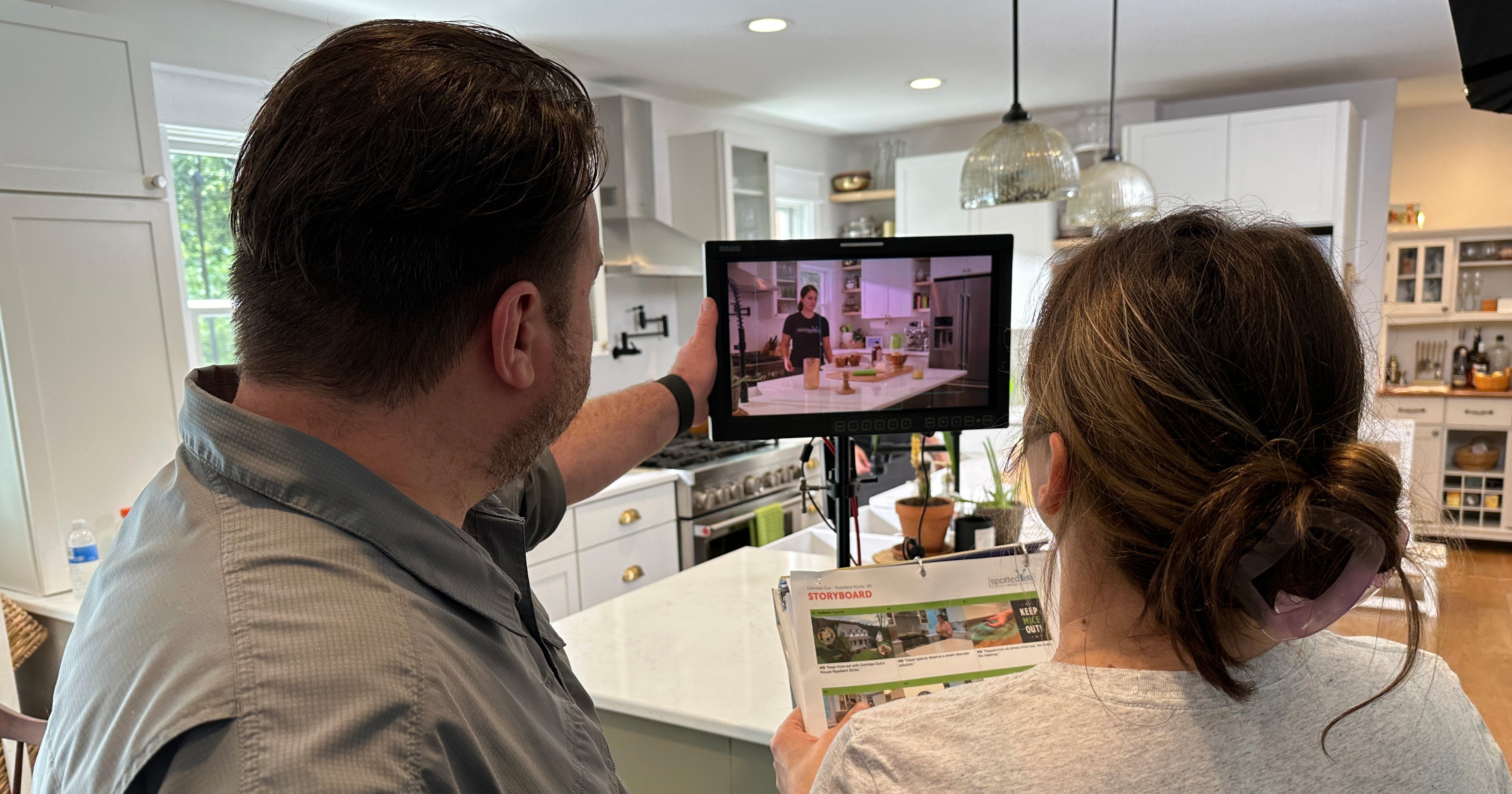 Director and Producer review a shot of a kitchen scene on a preview monitor.